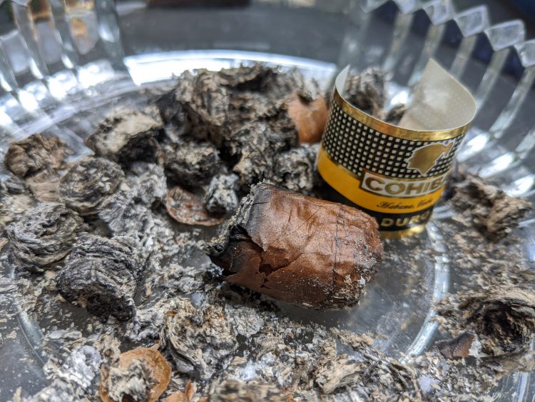 Cohiba Mágicos nub, lying amongst its ashes
